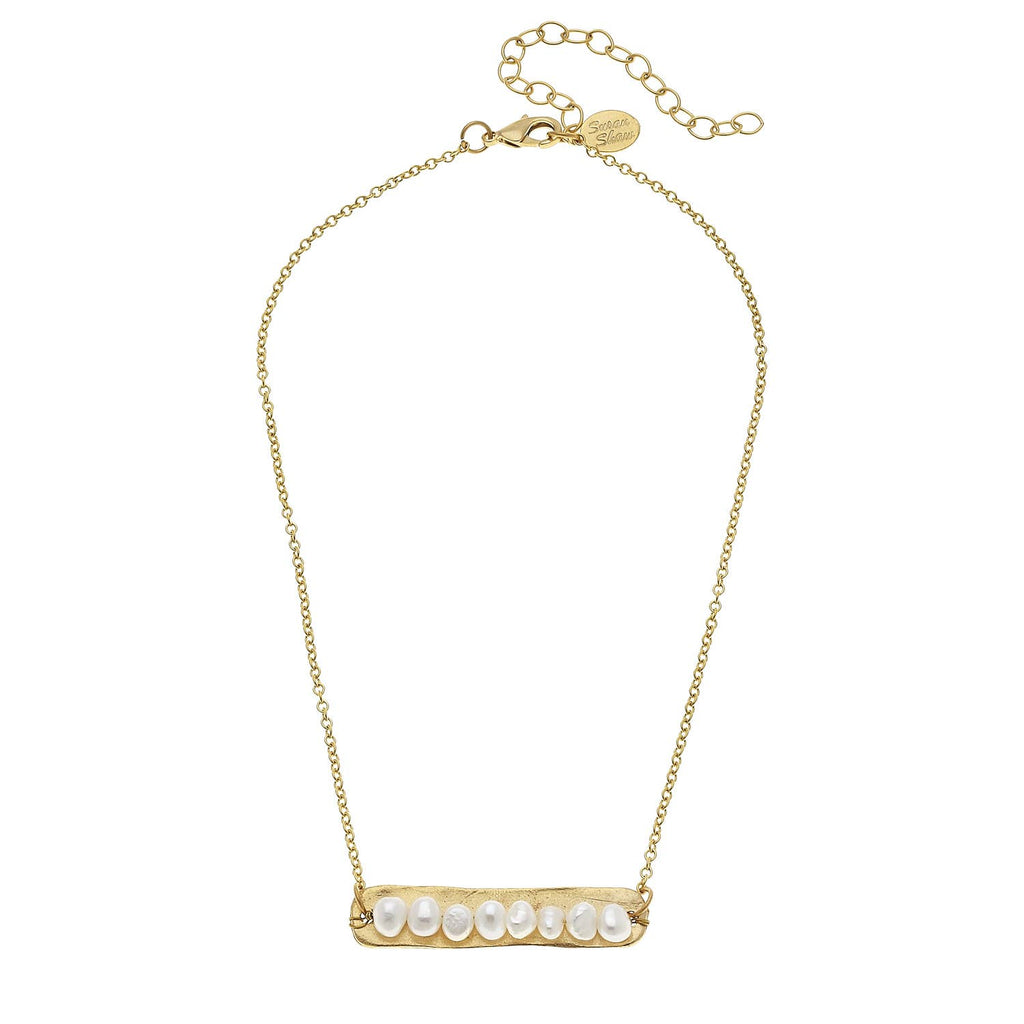 Gold necklace with a bar pendant featuring pearls on a white background