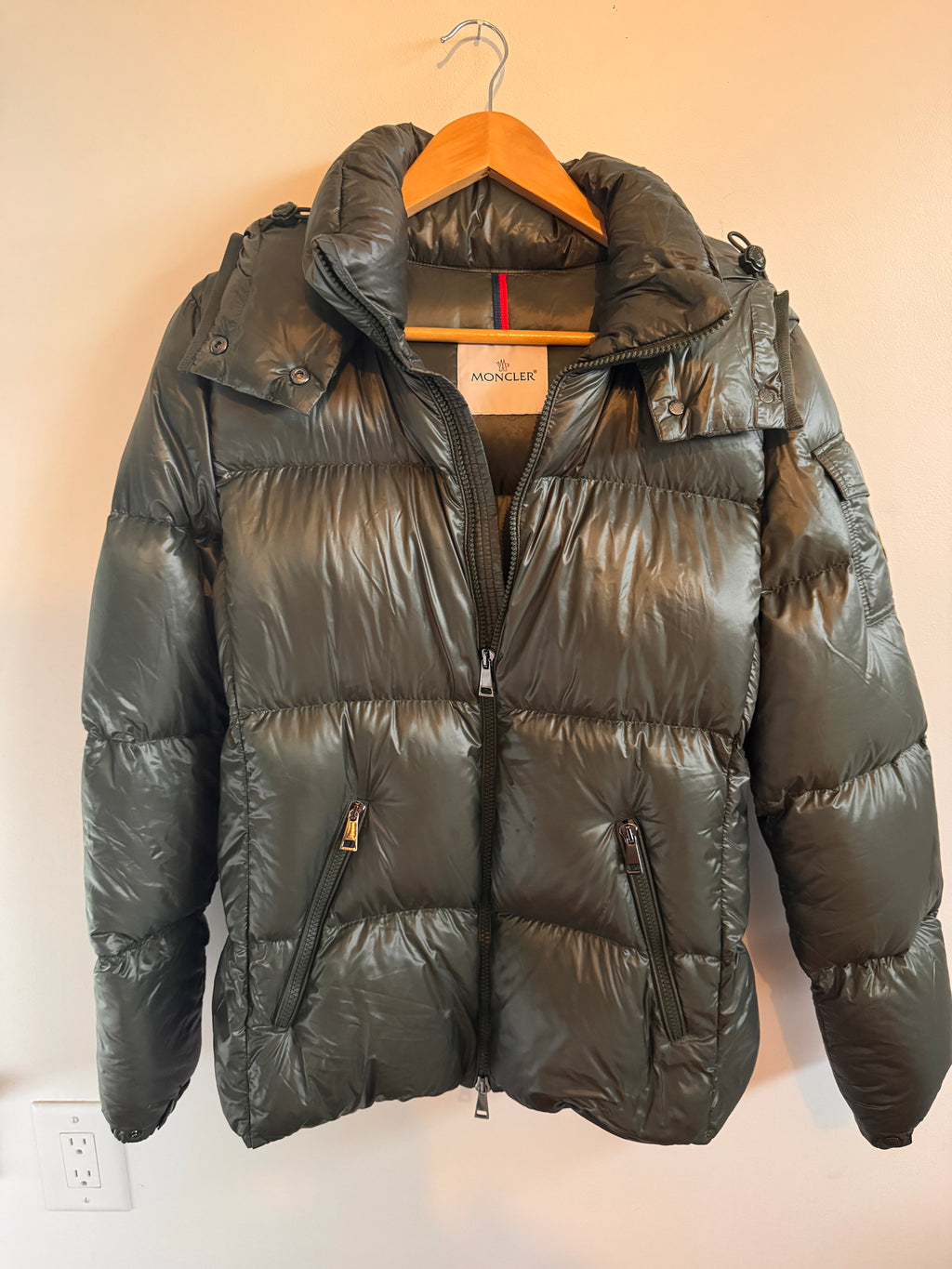 Olive puffer jacket on a beige background