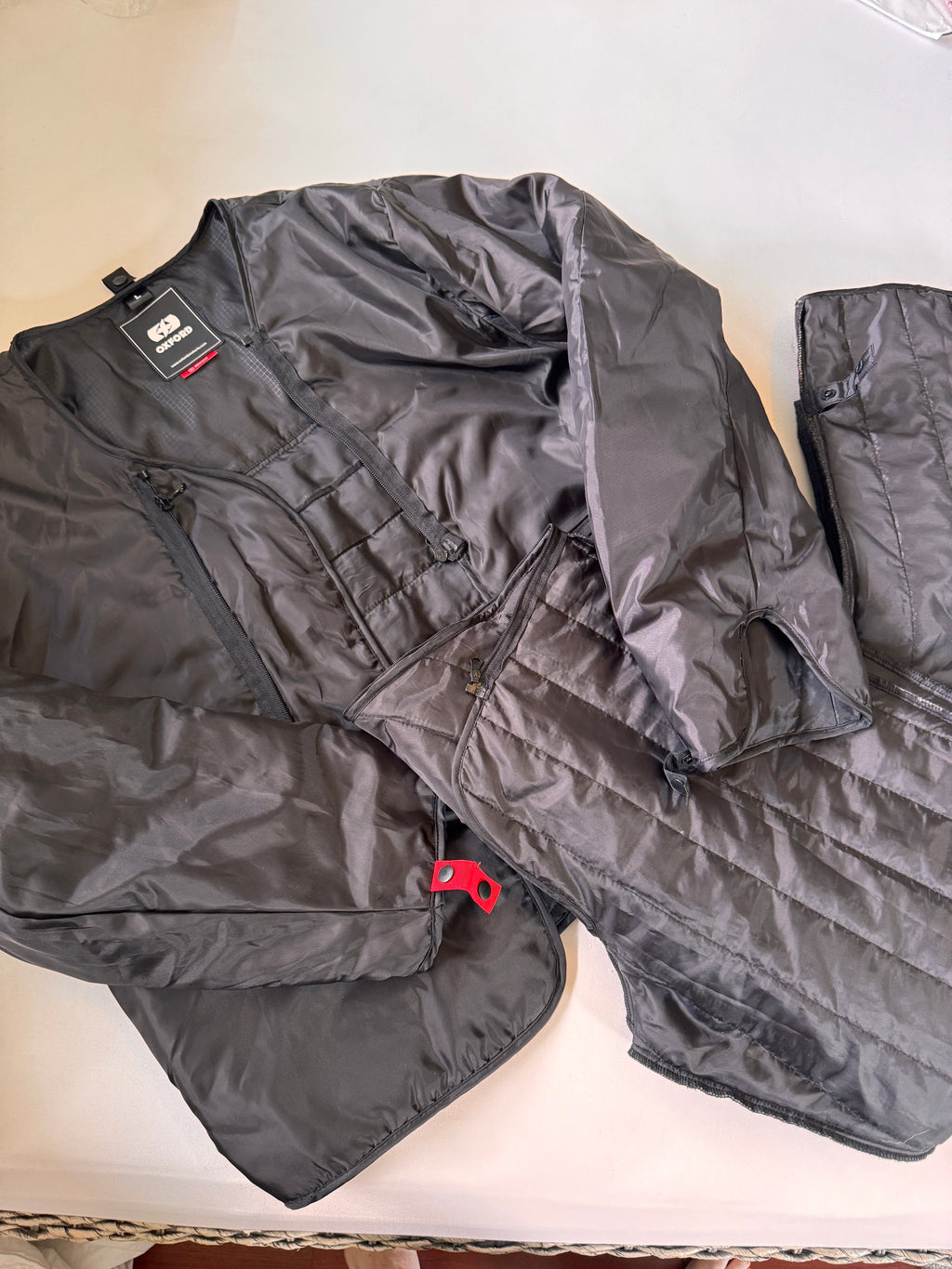 Warm lining for motorcycle jacket and pants folded on a white background