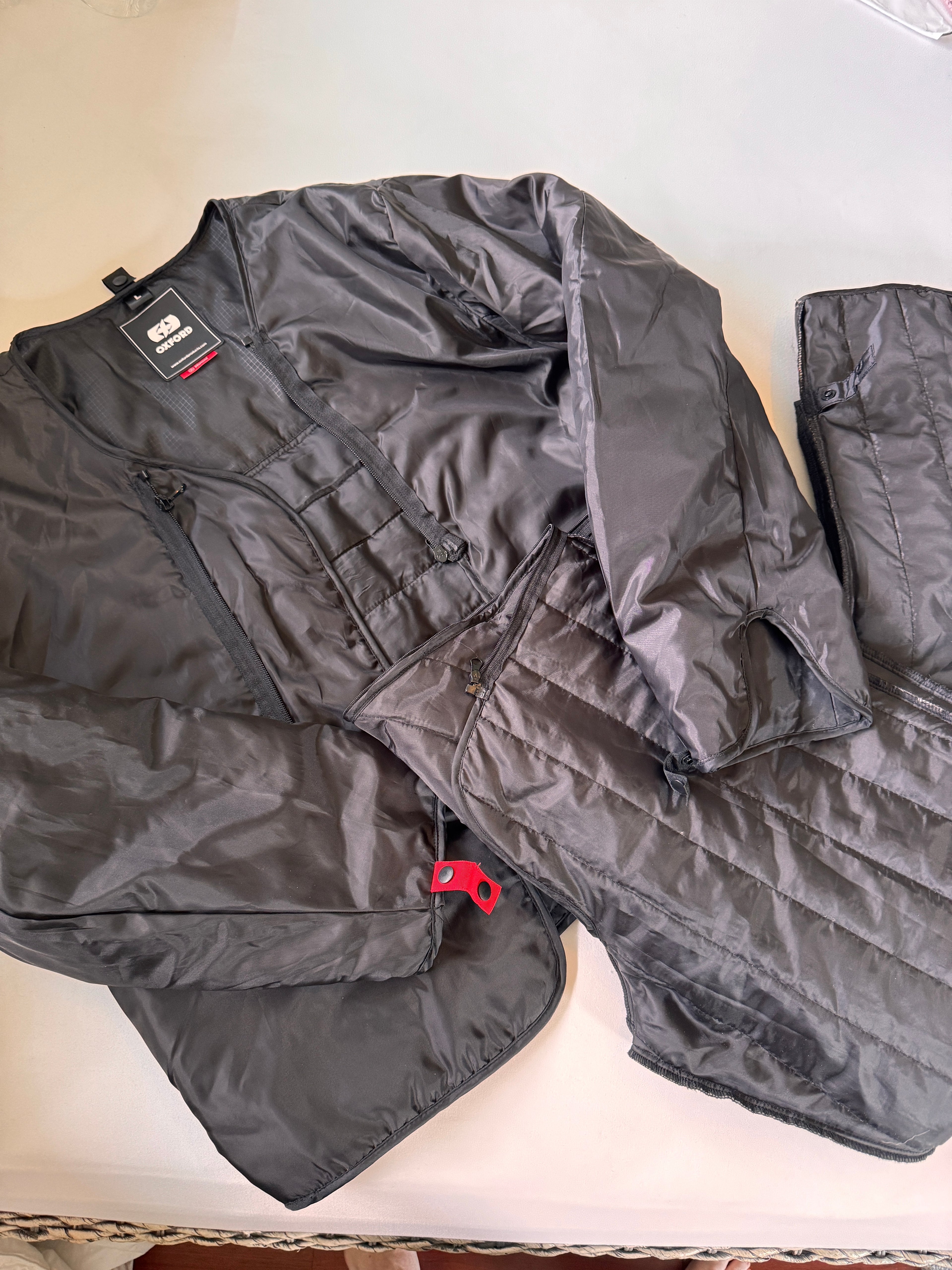 Warm lining for motorcycle jacket and pants folded on a white background