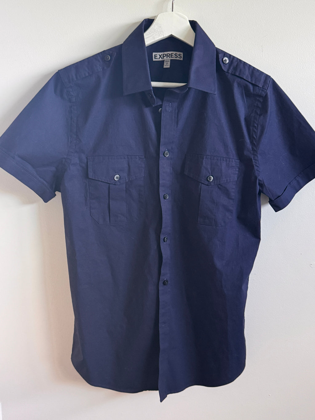 Hanging navy blue shirt on a white background