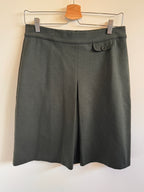 Dark olive skirt on a hanger against a plain background