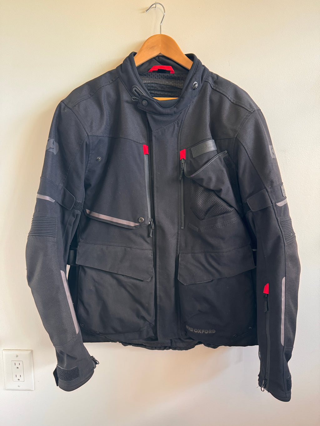 Mens black motorcycle jacket with red accents on white background 