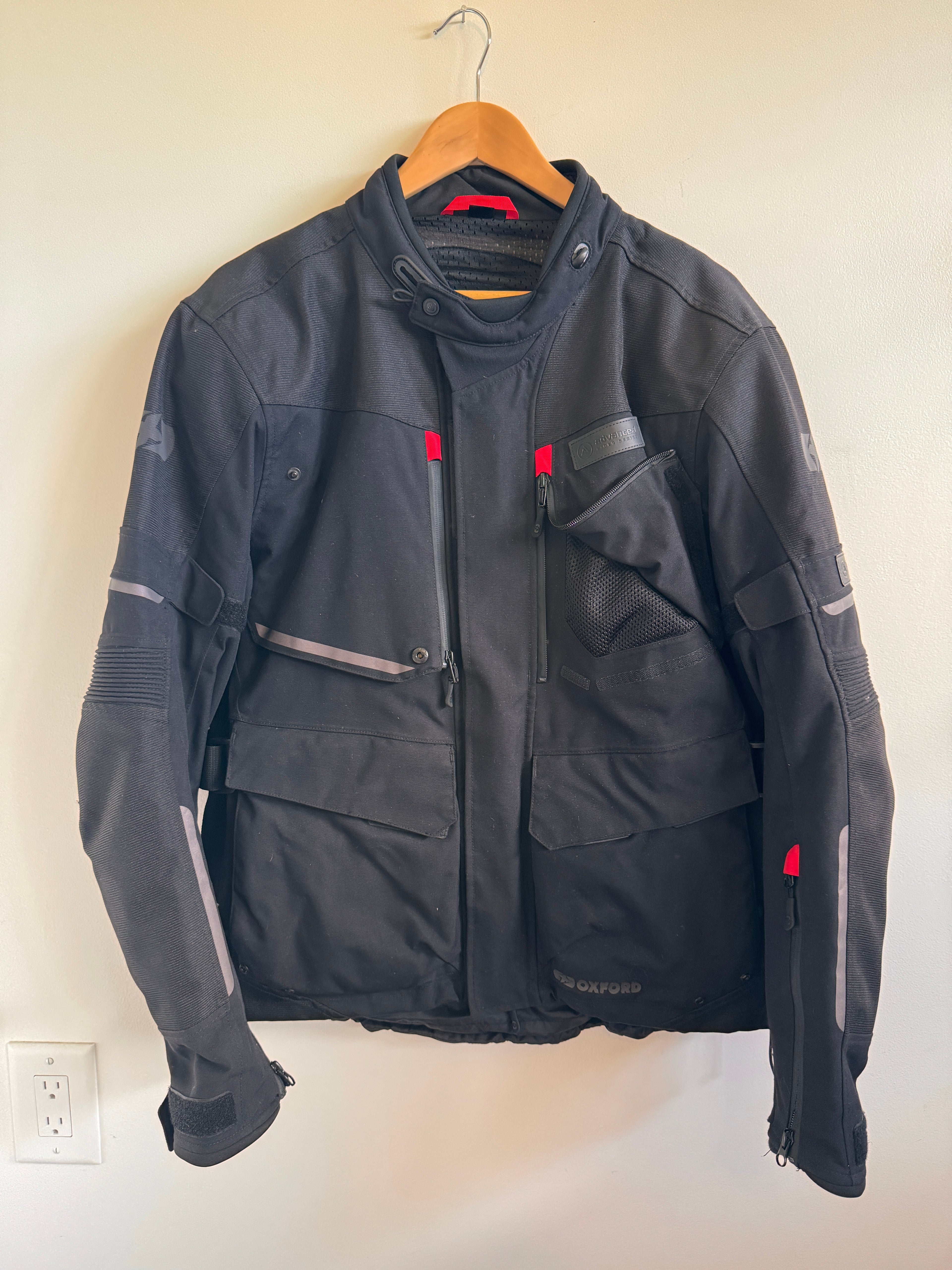 Mens black motorcycle jacket with red accents on white background 