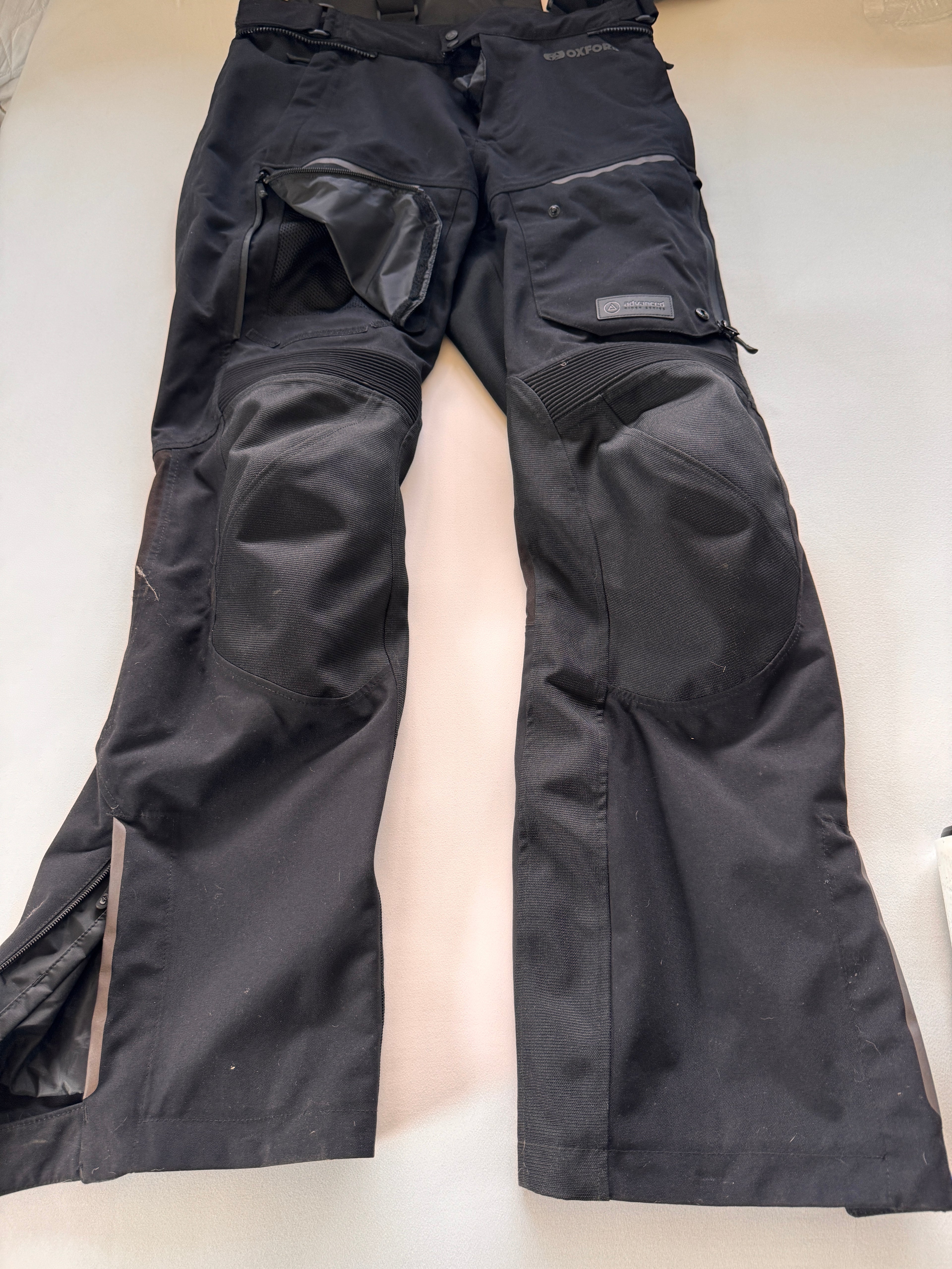 Black riding pants laid flat on a light-colored surface
