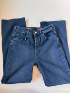 Folded pair of blue jeans on a light beige surface