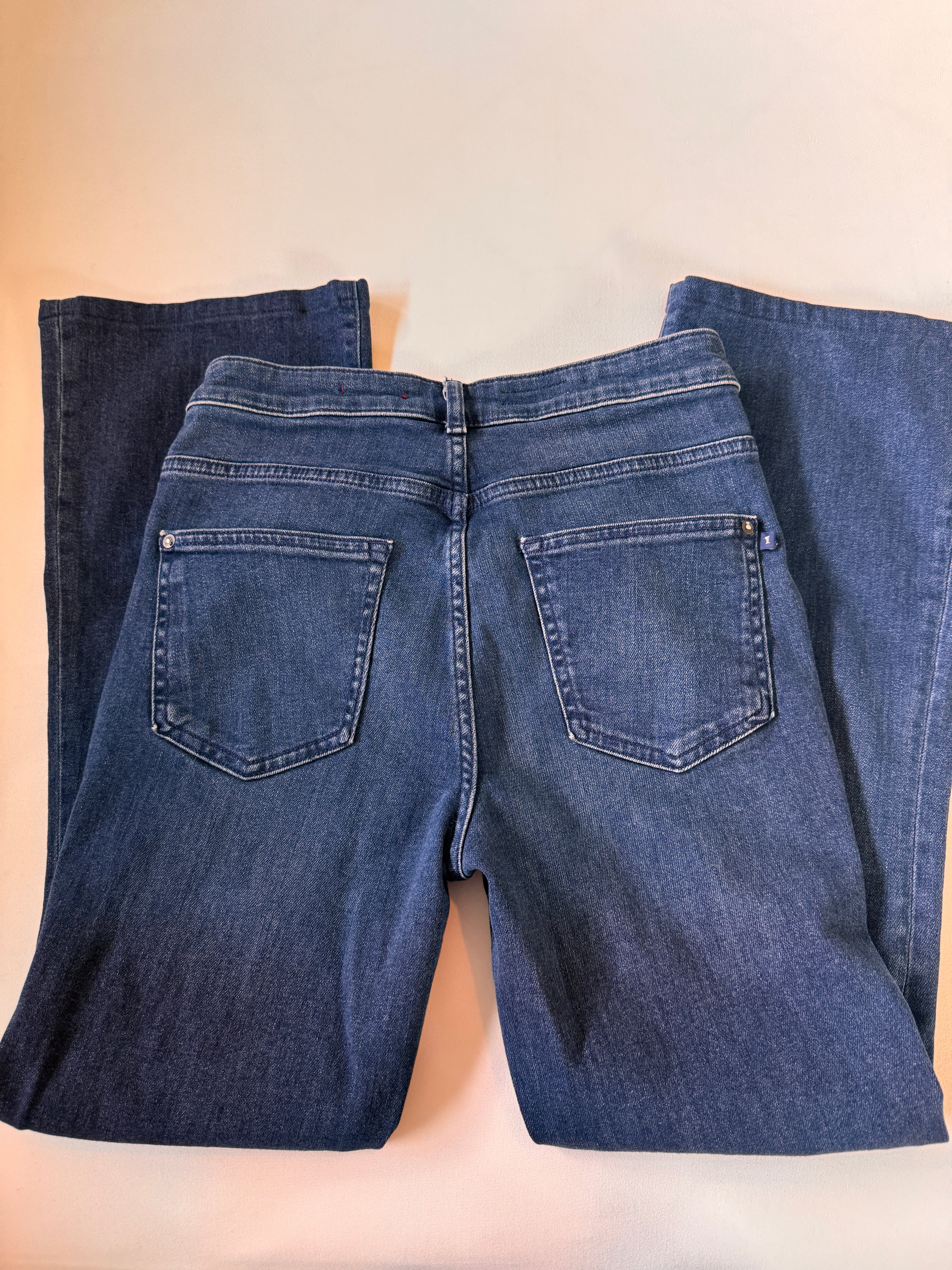 Pair of blue jeans on a beige background