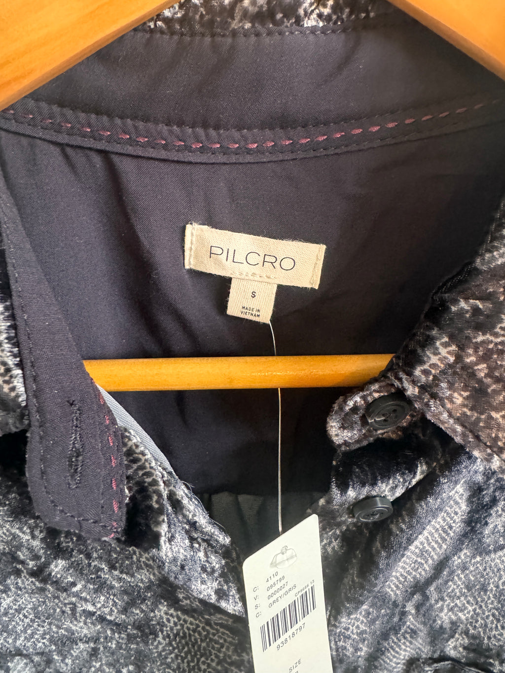 Shirt label Pilcro size small shown inside gray and black shirt on a brown hanger