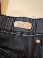 Close-up of dark blue denim fabric with a brand label on a beige background