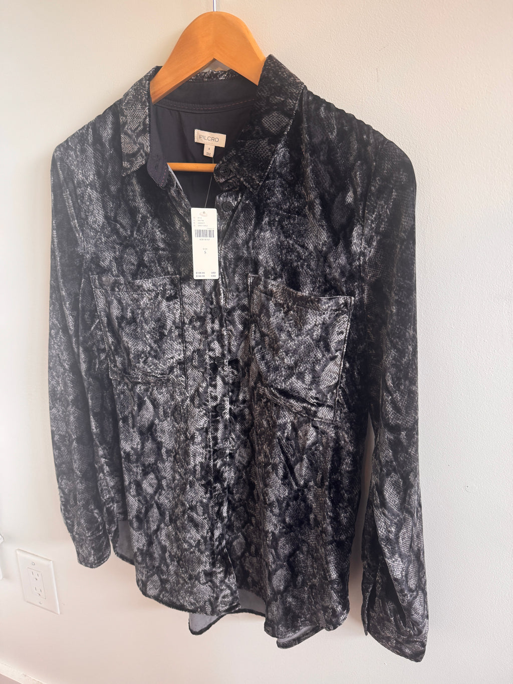 Folded black and gray patterned button up shirt on a white surface
