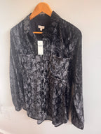 Folded black and gray patterned button up shirt on a white surface