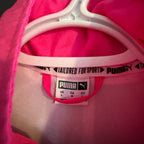 Pink garment with a Puma label on a pink background