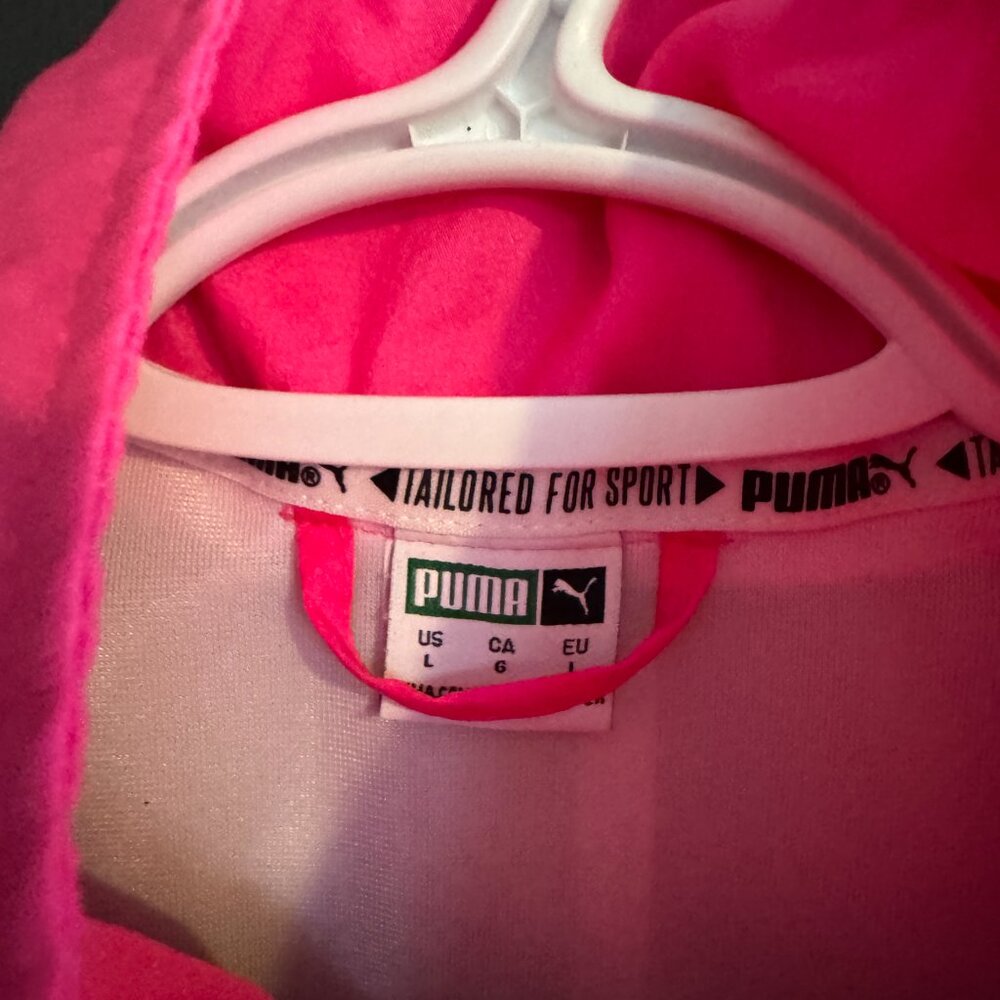 Pink garment with a Puma label on a pink background