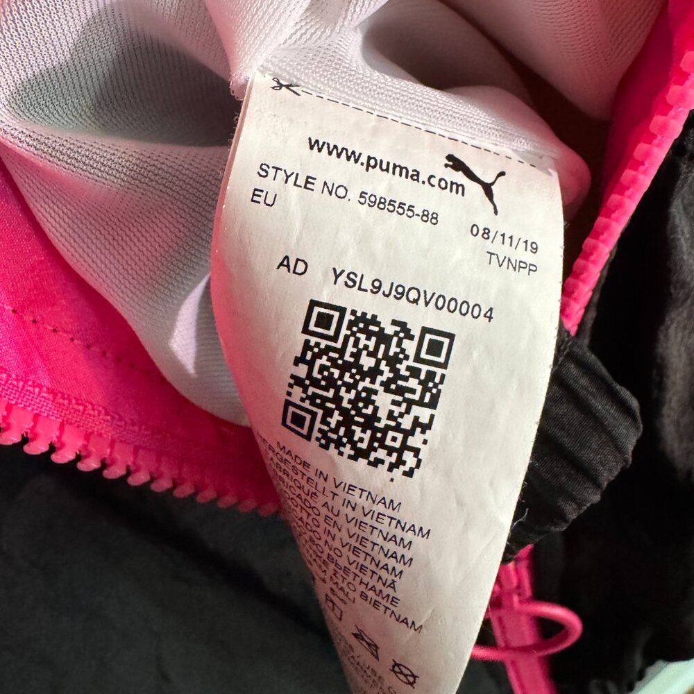 Close-up of a Puma product tag with QR code and text on a pink background