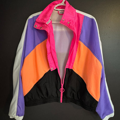 Colorful jacket with pink, purple, orange, and black sections on a dark background