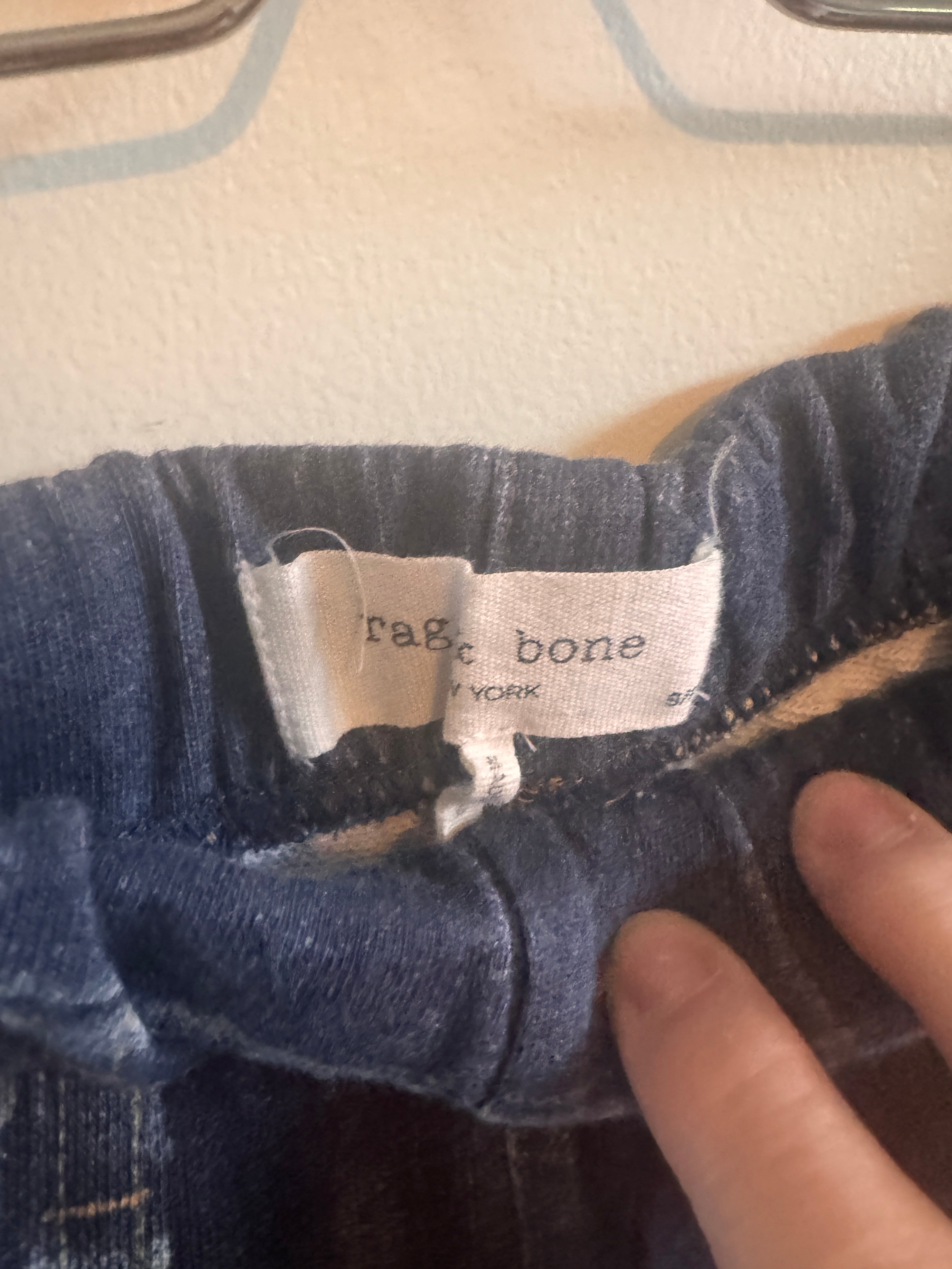 Close-up of a sweatpants with a brand label on a beige surface