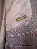 Close-up of a tailored jacket or blazer showing the interior lining, a small sewn label reading 'Regal Fit,' and a gray textured fabric pocket with stitched edges.