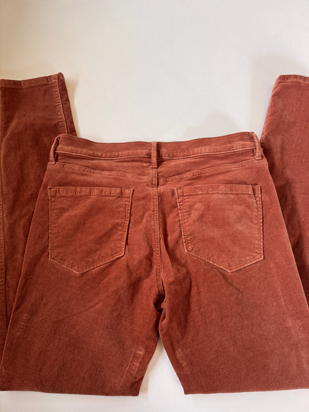 Brown pants laid flat on a white background