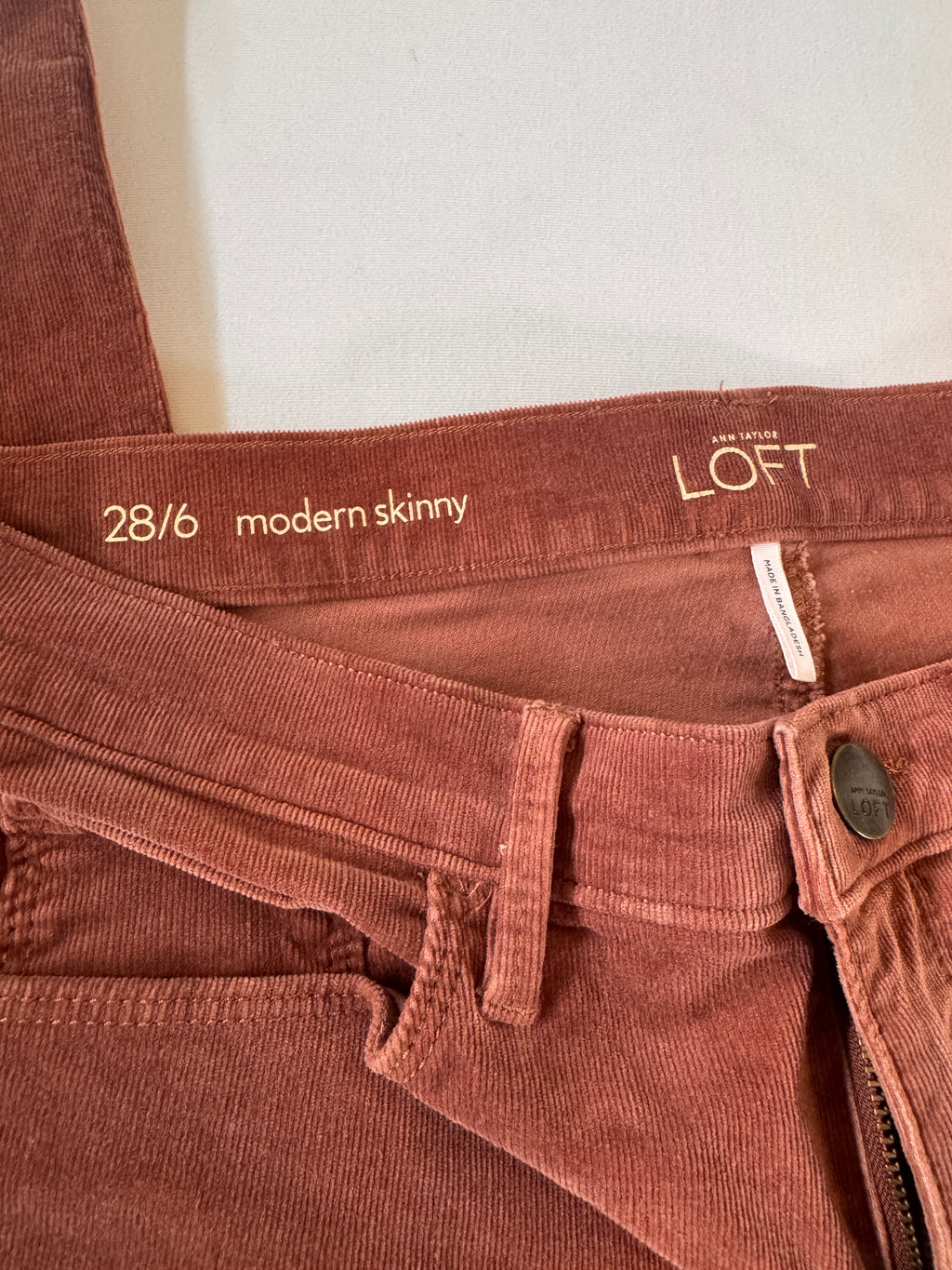 Brown pants with 'Loft' label and size information on a white background