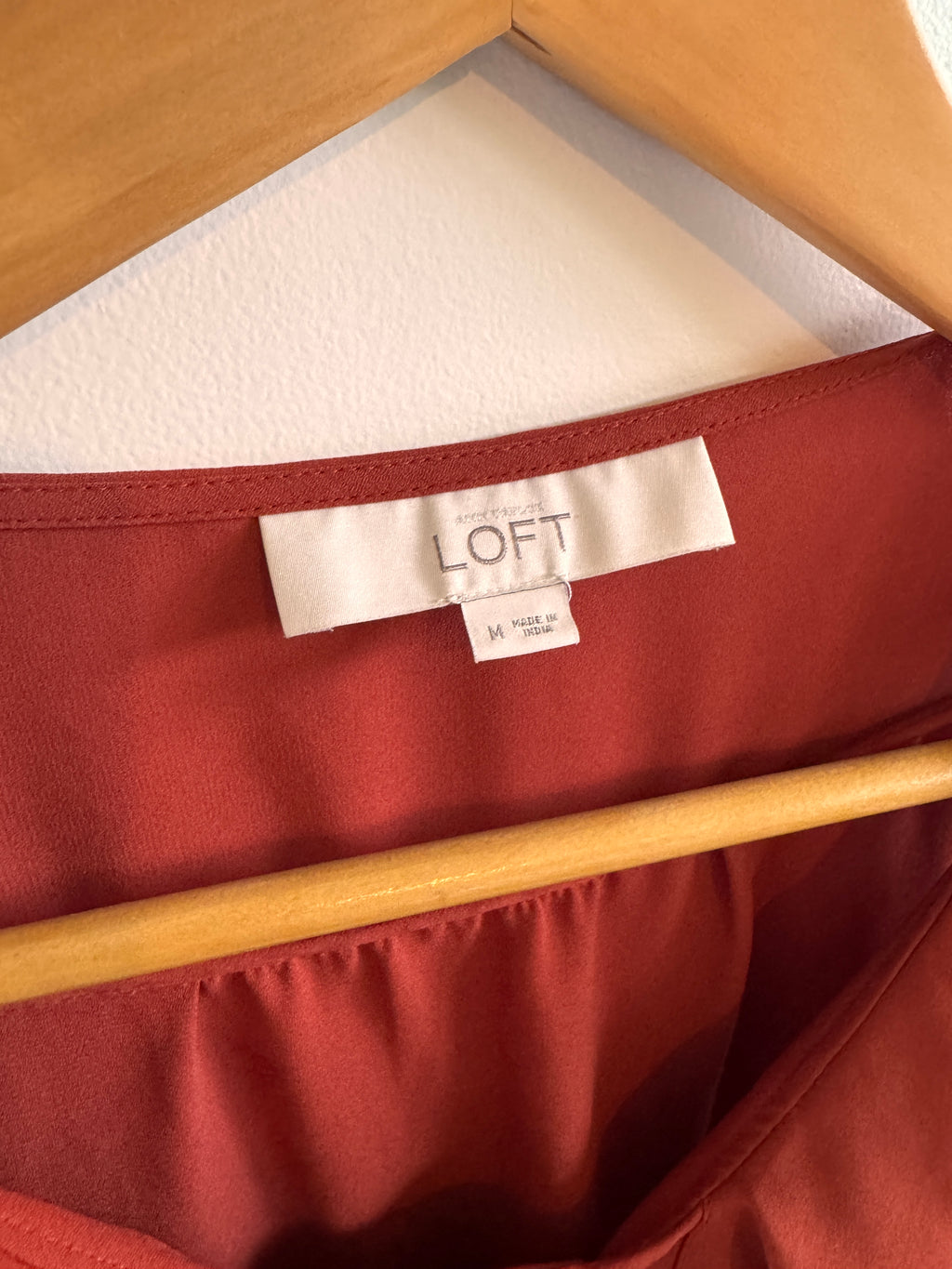 Close-up of a red fabric with a 'LOFT' tag, showing texture and color.