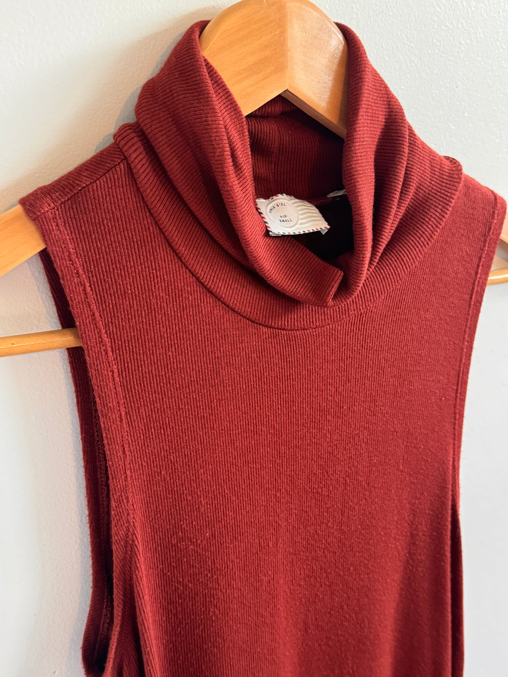 Red garment on a wooden hanger against a white background