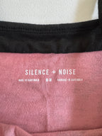 Close-up of a pink fabric with 'Silence + Noise' branding.