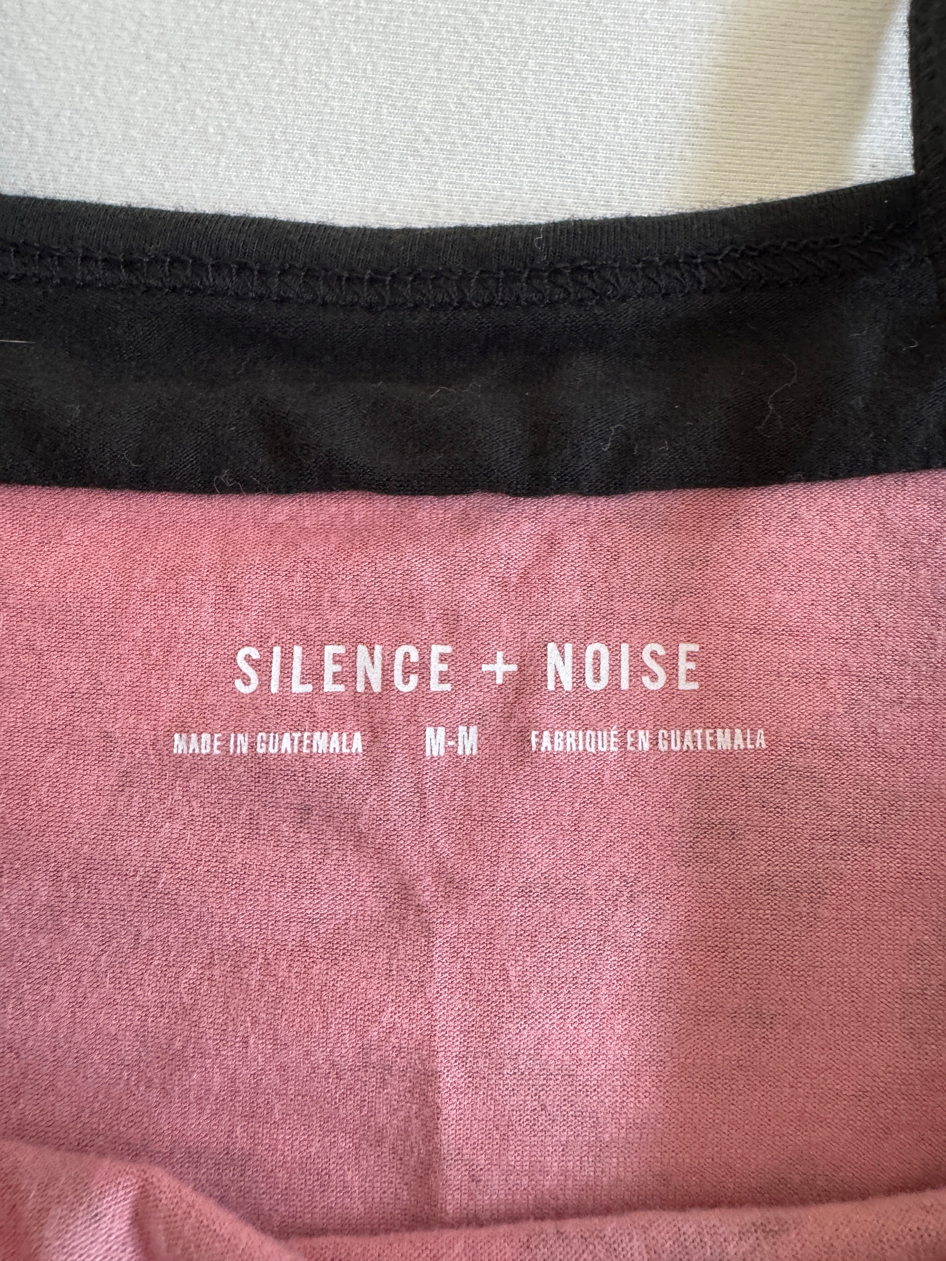Close-up of a pink fabric with 'Silence + Noise' branding.