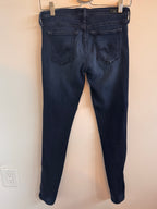 Pair of dark blue jeans on a beige surface