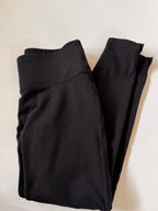 Folded black pants on a light beige background
