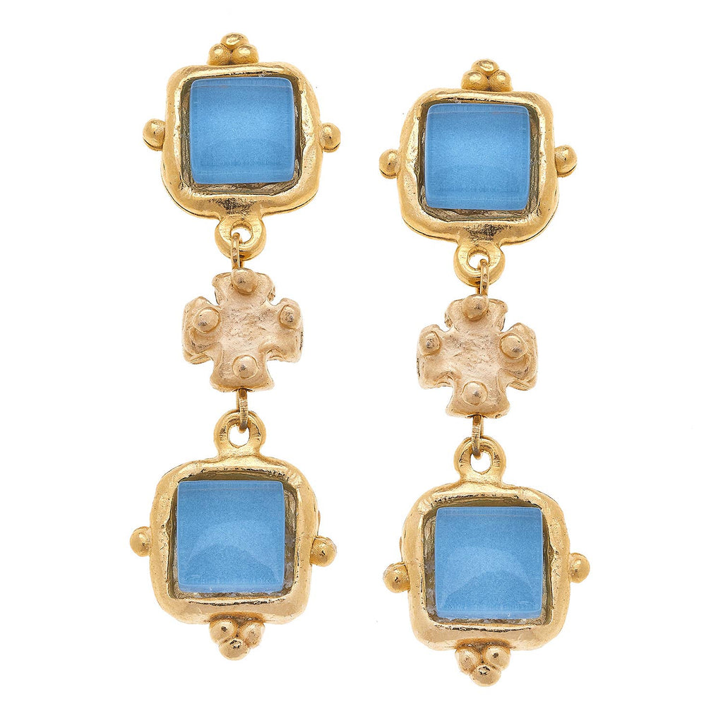 Gold earrings with blue gemstones on a white background