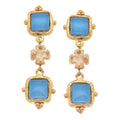 Gold earrings with blue gemstones on a white background