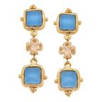 Gold earrings with blue gemstones on a white background