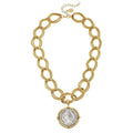 Gold chain necklace with a coin pendant on a white background