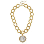 Gold chain necklace with a coin pendant on a white background