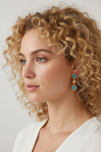 Woman with blonde curly hair wearing minimal small earrings