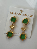 Gold and green earrings on a Susan Shaw branded card.