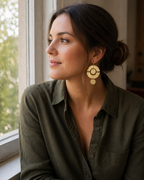 Woman wearing earrings sitting near a window