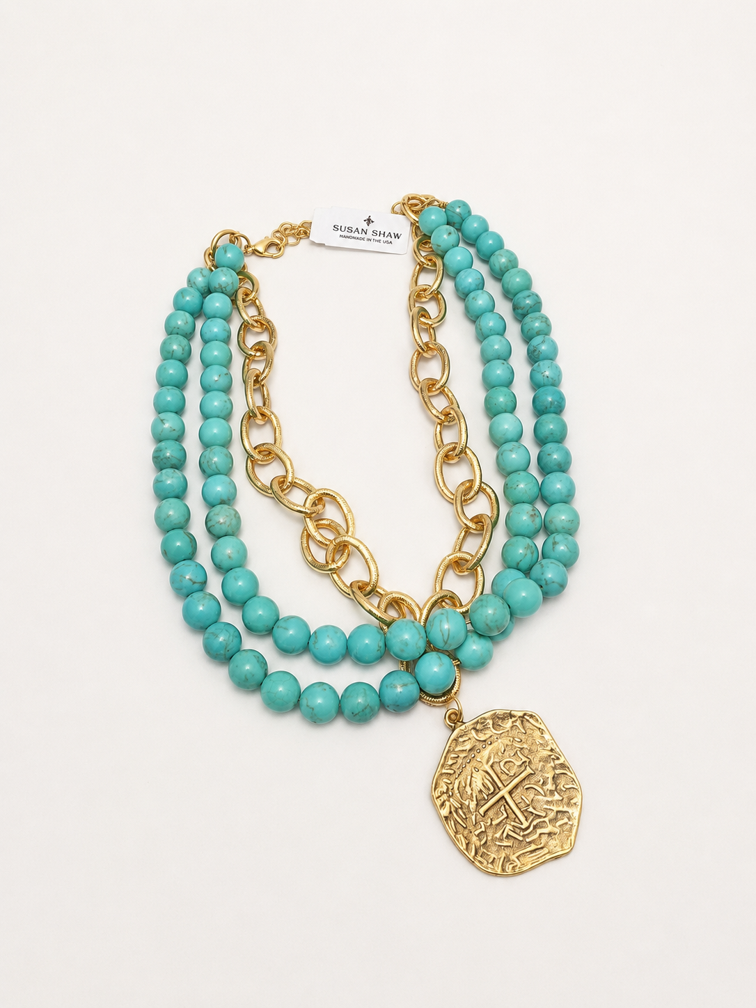 Turquoise beaded necklace with gold chain and pendant on a white background