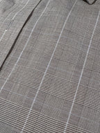 Close-up of a gray and white plaid fabric pattern with a fine woven texture.