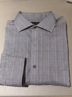 A folded gray long-sleeve dress shirt with a subtle white windowpane plaid pattern, displayed on a light beige textured surface.