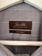 Close-up of the inside collar of a Tasso Elba Regular Fit non-iron shirt, showing the brown brand label and the gray and white plaid fabric.