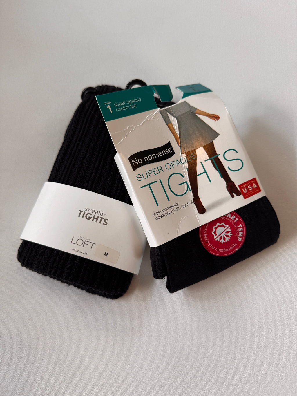 Pack of black tights with packaging on a light gray background