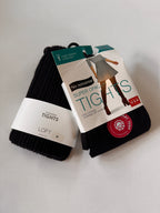 Pack of black tights with packaging on a light gray background