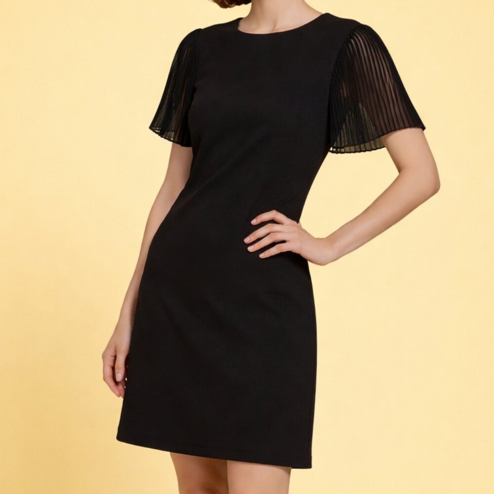 Black dress with sheer sleeves on a yellow background