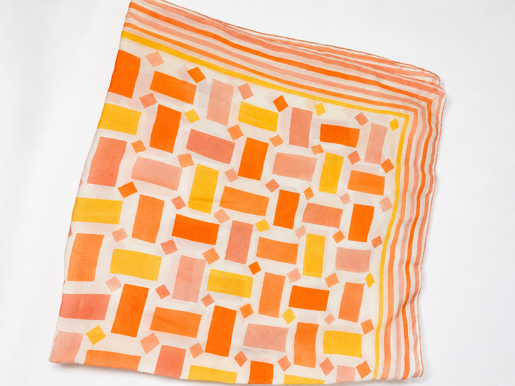 Square scarf with orange and yellow geometric pattern on a white background