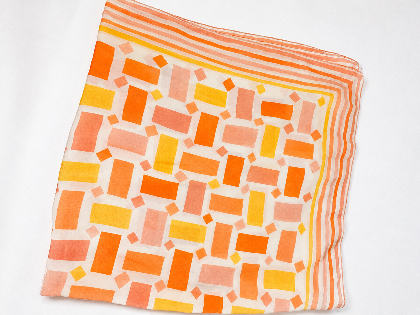 Square scarf with orange and yellow geometric pattern on a white background