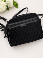 Black quilted handbag with floral decorations on a white background