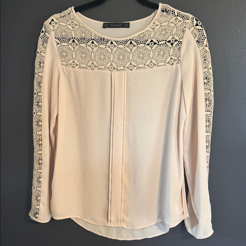 Beige blouse with lace details on a dark background