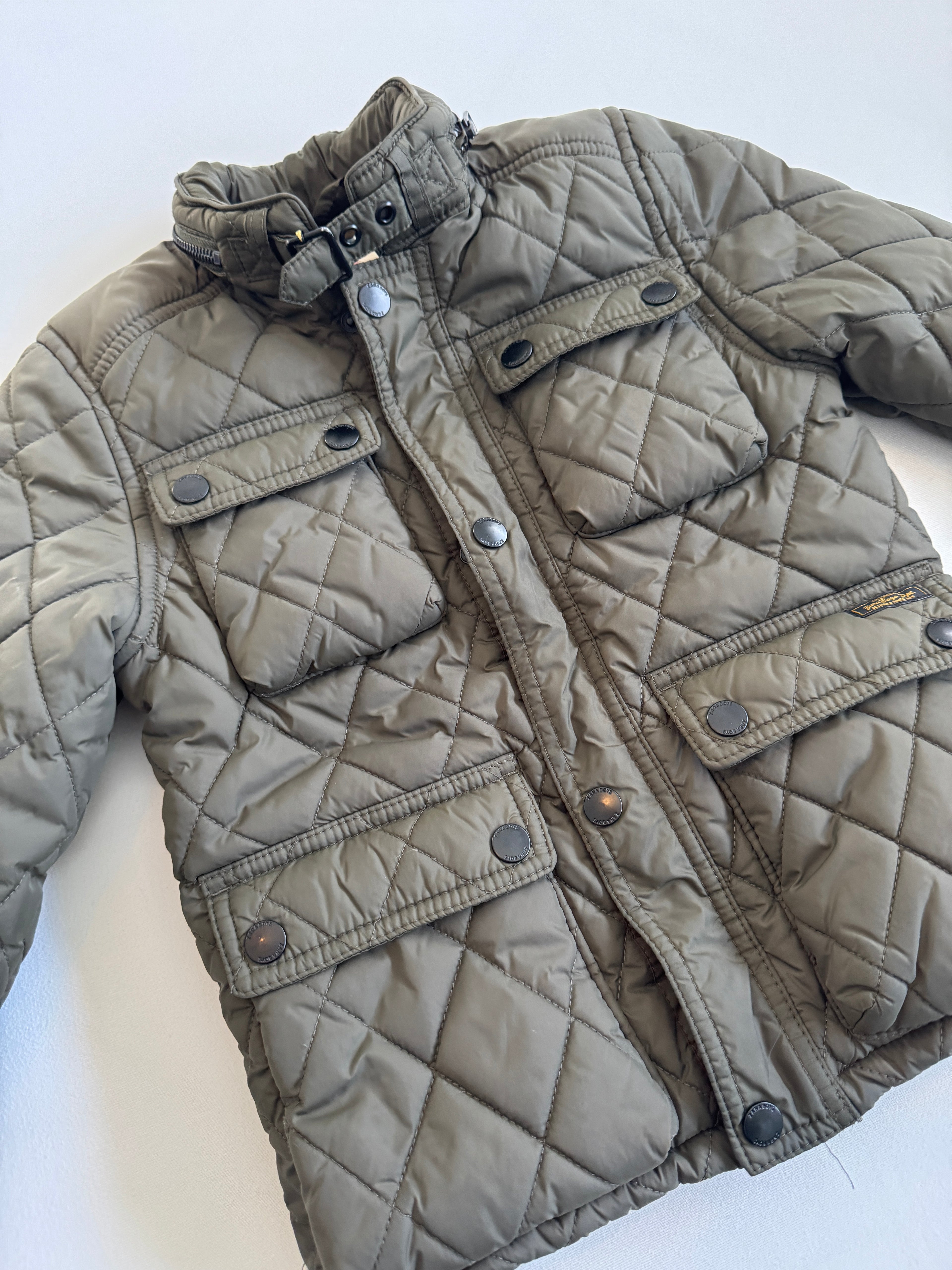 Quilted jacket with button details on a white background
