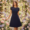Woman in navy lace dress with flared skirt in floral setting